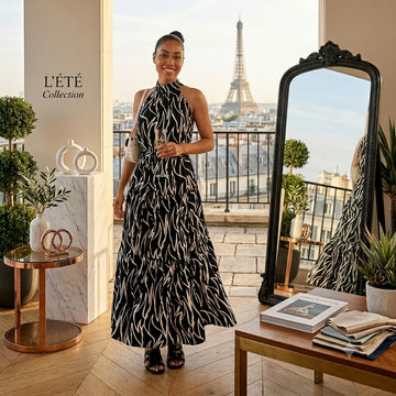 Verona Noir Maxi Dress with halter neckline and flowing silhouette, styled against a backdrop of the Eiffel Tower.