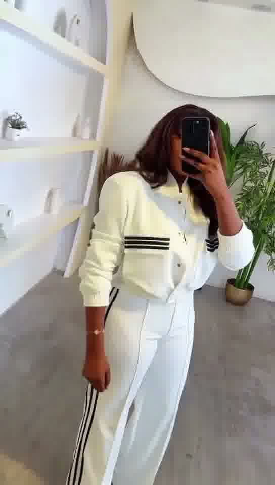 Person wearing a white outfit with black stripes in an indoor setting.