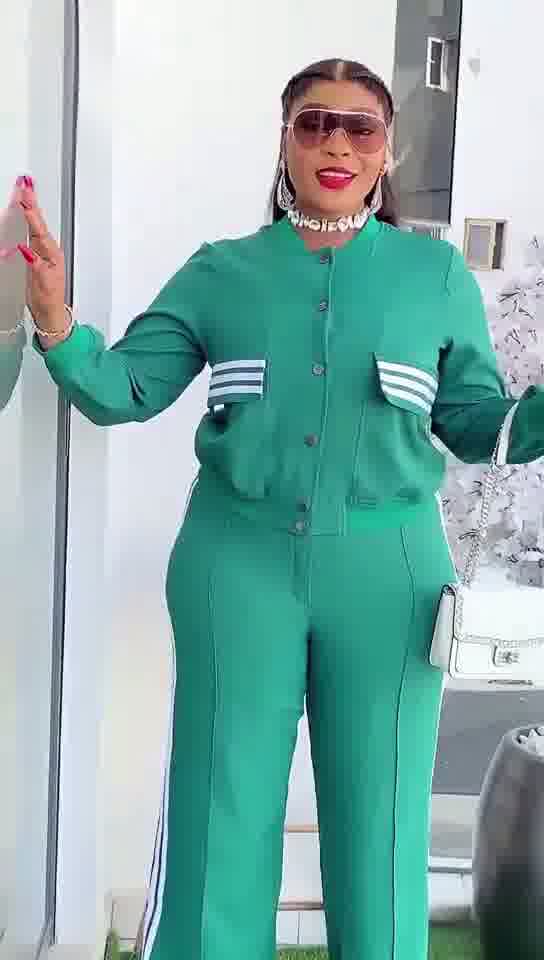 Person wearing a green tracksuit with white stripes indoors