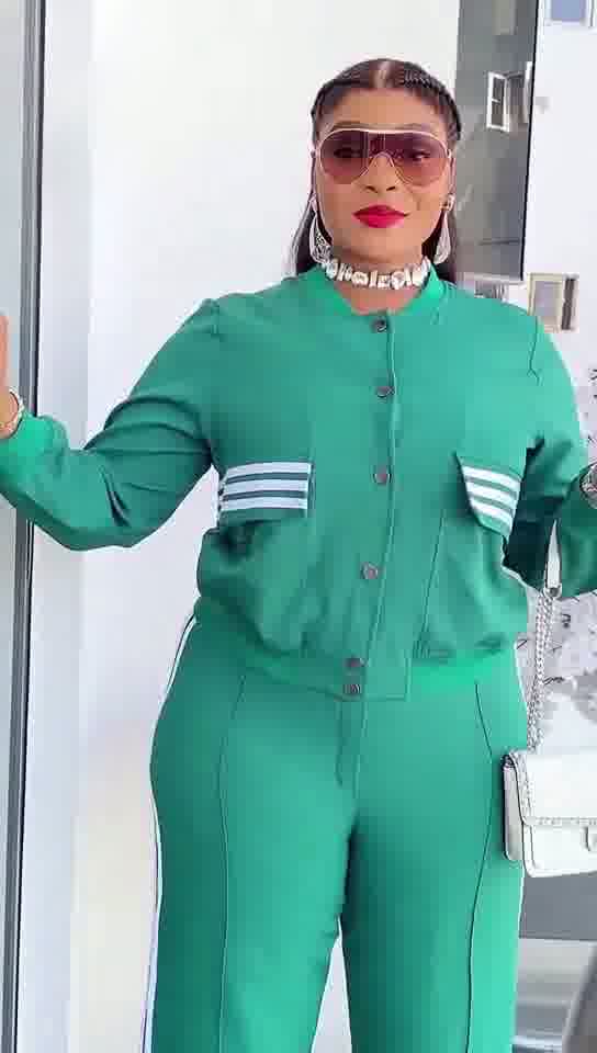 Person wearing a green tracksuit with white stripes in an indoor setting